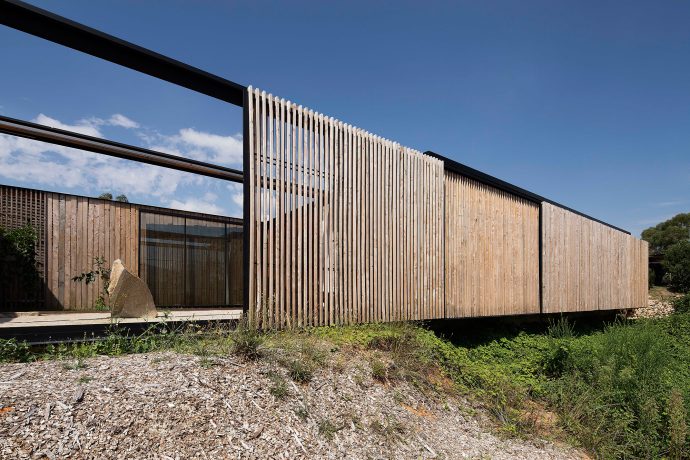 The house's eucalyptus timber facade is designed to fade, ageing gracefully with time. Photo by Ben Hosking.