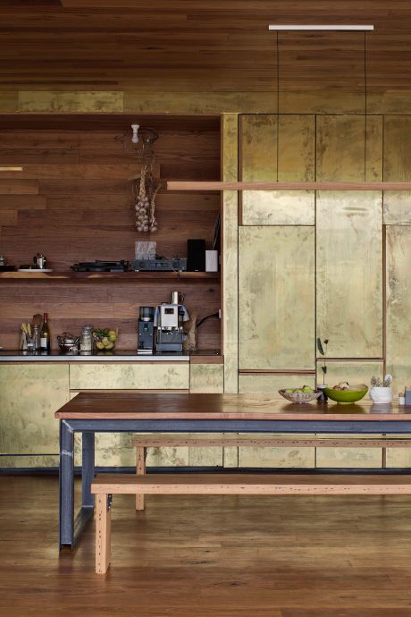 Bespoke details, including brass cabinetry and recycled hardwood floors, lend a personal yet polished feel to the building's interior. Photo by Ben Hosking.