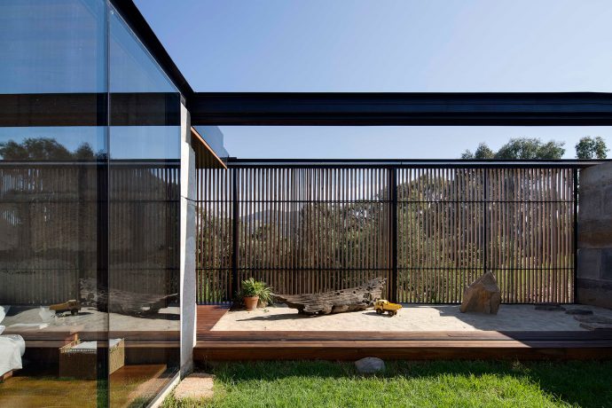 Strong horizontal lines, permeable screens and a striking use of glass results in a distinct blending of inside and out. Photo by Ben Hosking.