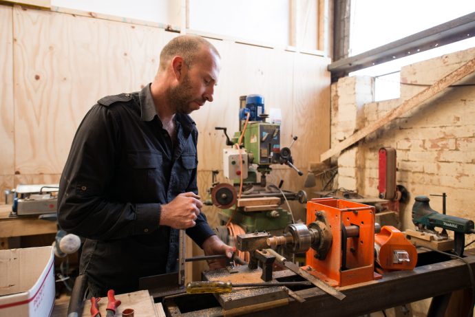 Due to an evolving demand for Grafa products, the couple have relocated their main workshop, office and studio space to Sunshine. Here, Travis gets handy with the power tools in the new space. Photo by Fred Kroh.