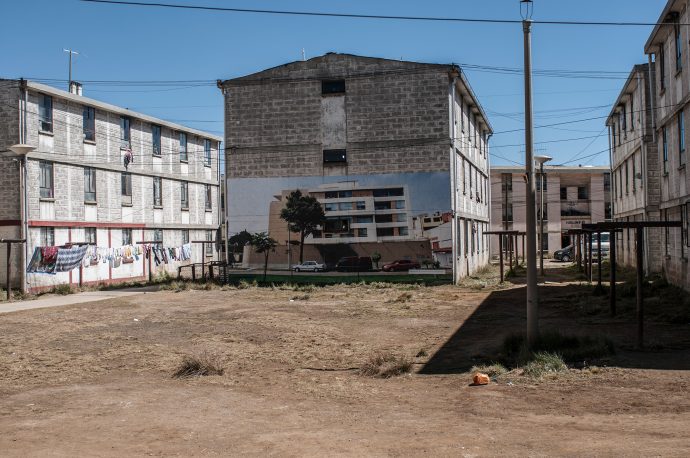 Artist Daniela Ortiz’s intervention ‘1st of May camp’, in which photographs of the luxury city residences of the directors of Volcan (the mining company that owns and operates the Cerro de Pasco mine) were pasted onto the walls of the mine workers’ housing. Photo by Xose Quiroga.