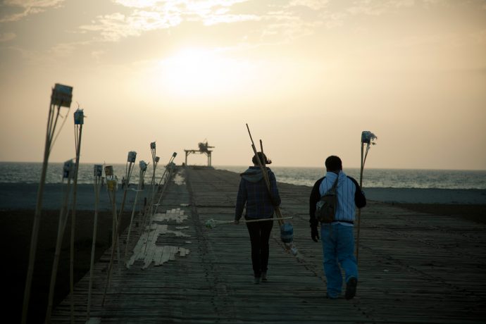 Pamela Arce prepares her installation ‘Los Ojos de Judas’ on the abandoned Pisco pier. Photo by Dana Bonilla.