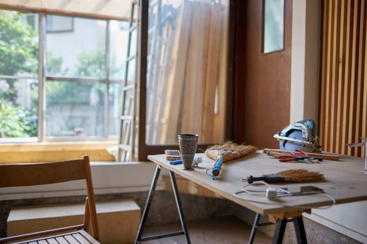 Japanese artist Satoshi Murakami’s studio showcasing alternative ways of living | Desk, chair, broom, saw and window in Japanese man’s studio | Japanese house Tokyo | Co-working space | artists collective space | Japanese artists | Written by Grace Lovell and Yoshi Tsujimura Photography by Yoshi Tsujimura | edited by Sophie Rzepecky