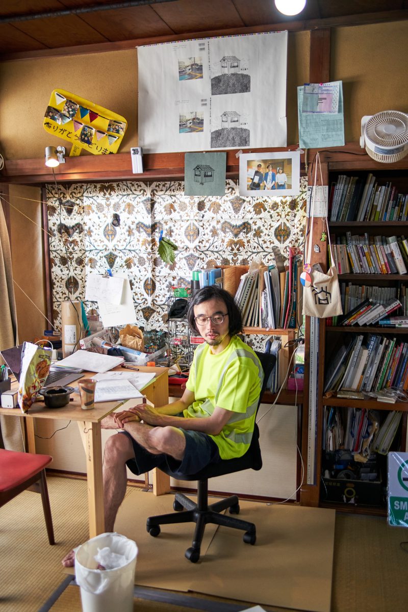 Japanese artist Satoshi Murakami in his studio showcasing alternative ways of living | Japanese man at desk surrounded by books papers and drawings | Japanese house Tokyo | Co-working space | artists collective space | Japanese artists | Written by Grace Lovell and Yoshi Tsujimura Photography by Yoshi Tsujimura | edited by Sophie Rzepecky