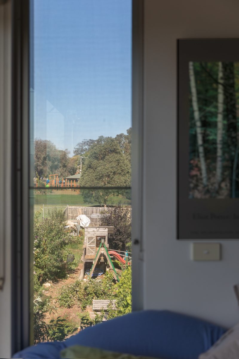 Housing Co-operative Murundaka showcases how transformative change is possible in the suburbs of Melbourne | Looking out the window of an apartment down to a wooden playground, slide and green garden | Co-op living Australia | cohousing collective | Photography by Jasmine Fisher | edited by Jana Perković | Assemble Papers